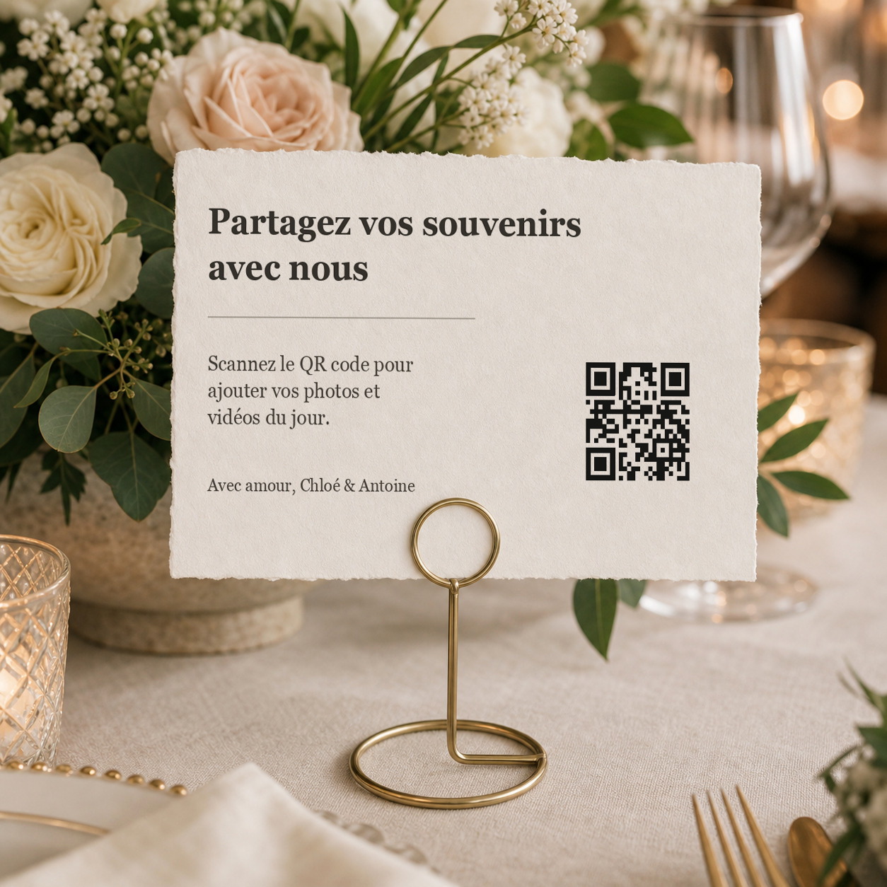 Carte QR code Forever Memories tenue par un support métallique doré sur une table de mariage
